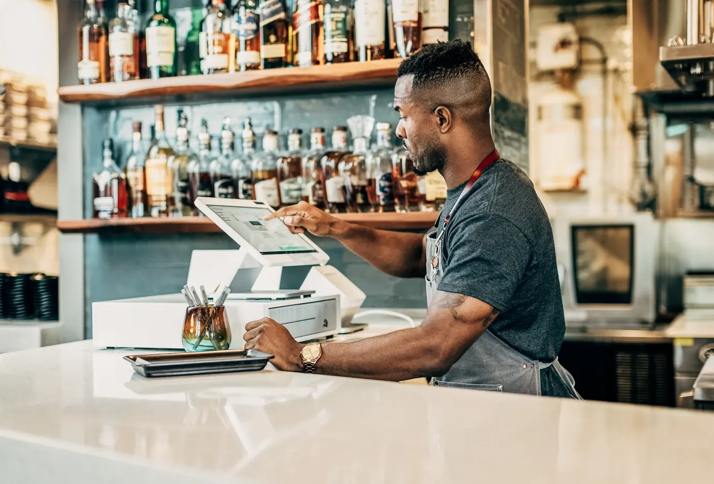 A bartender ringing up an order on a Clover Station Solo
