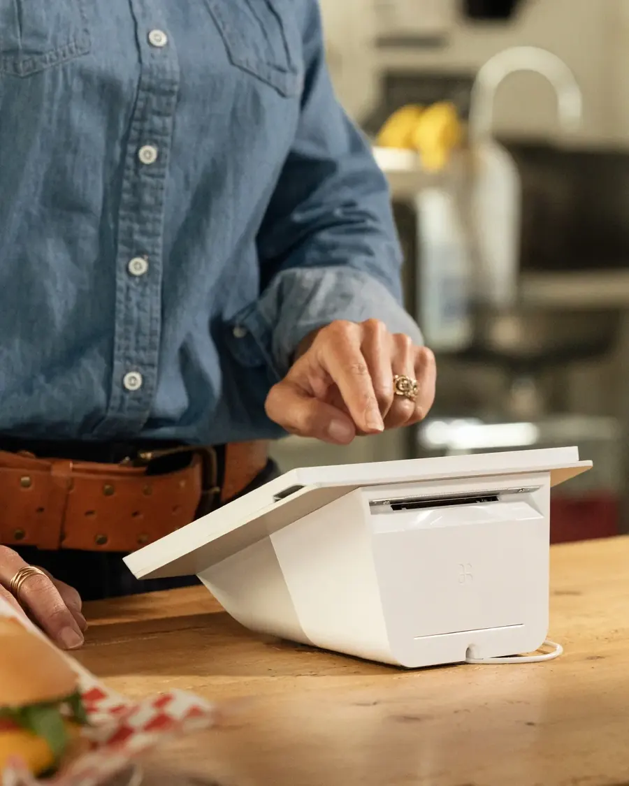 A cafe customer entering a PIN on a Clover Mini