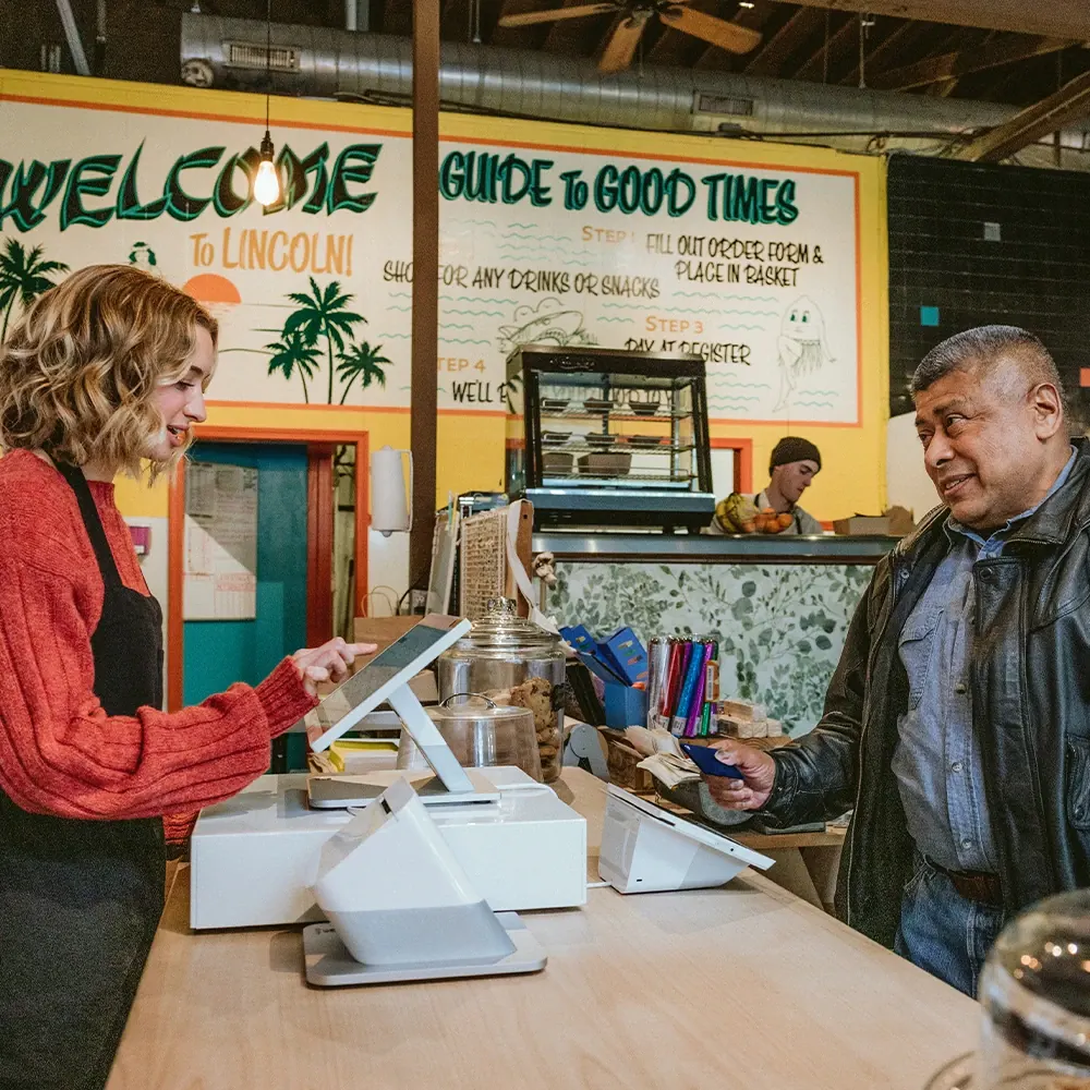 A deli owner ringing up a customer on a Clover Station Duo