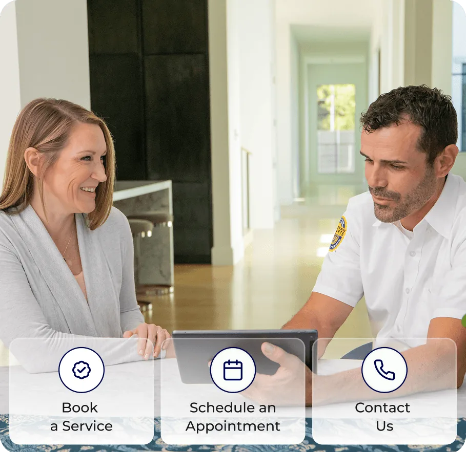 A homeowner booking service with a technician at her kitchen table