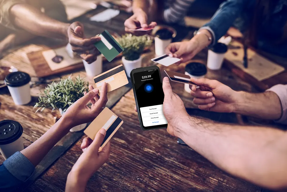 A group of friends each paying their share at the table with a Shift4 Dine handheld