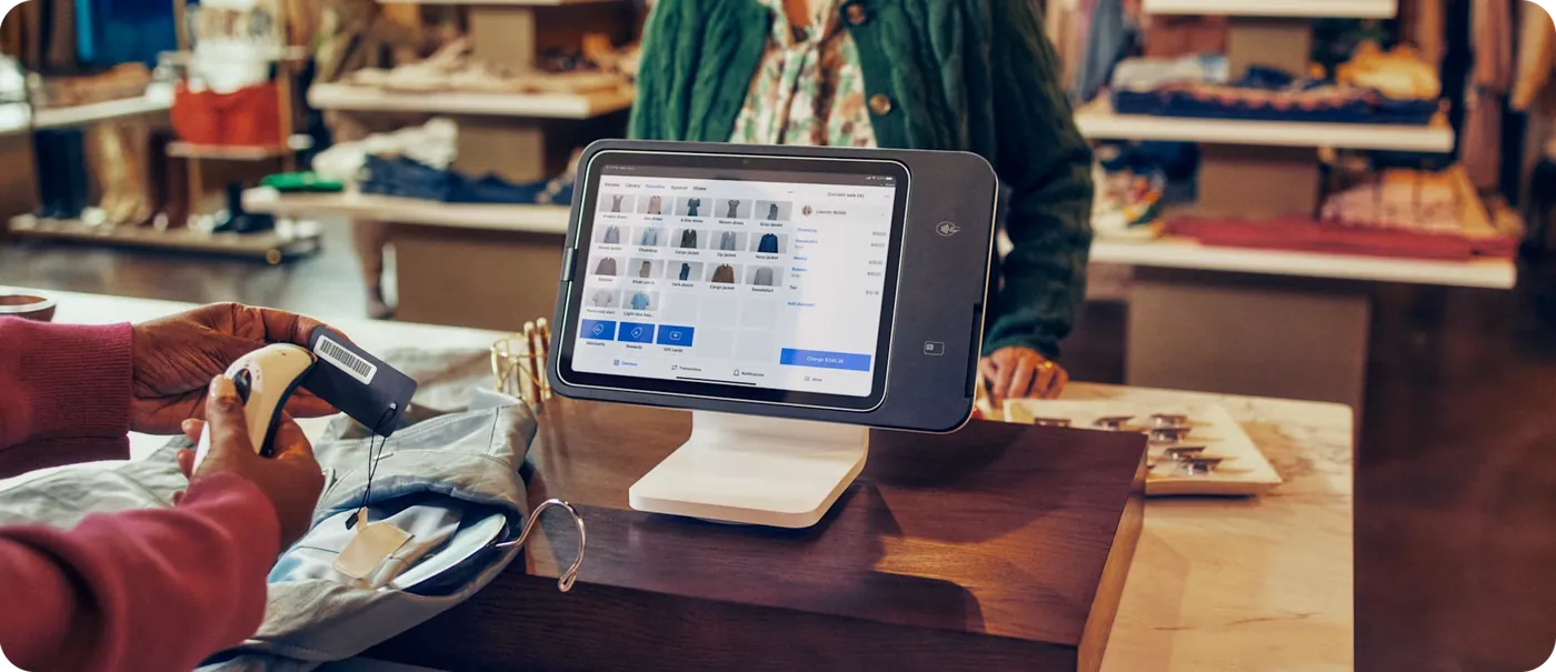 A clothing store employee scanning an item at Square Stand