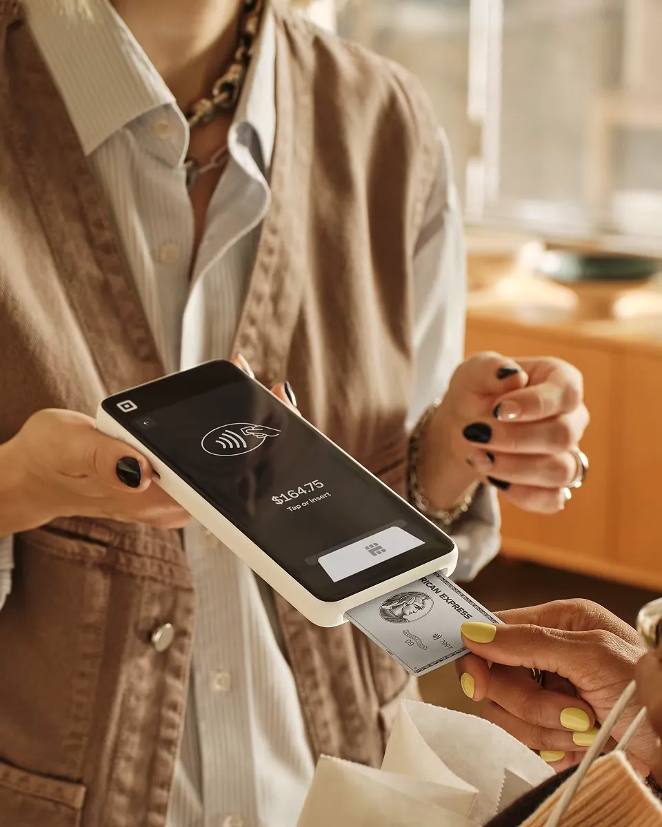 A cafe guest paying with Square Handheld