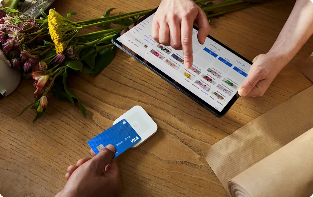 A florist taking a card payment with Square Reader and a tablet